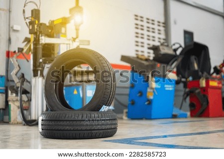 Car tires lying near modern tire changer in auto service center