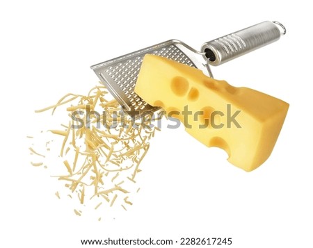 Piece of cheese is rubbed on a hand grater Royalty-Free Stock Photo #2282617245