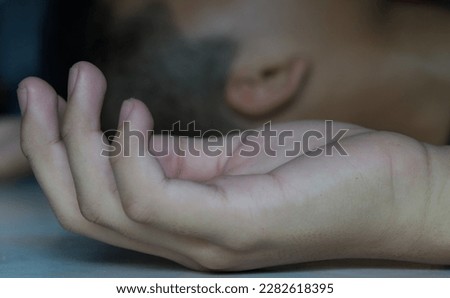 Close up of man hand.Losing consciousness to a sudden and temporary loss of awareness or responsiveness. It can be caused by various factors, including trauma, illness, and dehydration. Royalty-Free Stock Photo #2282618395