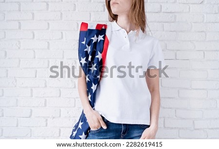 White polo shirt on woman over USA flag background, mockup design. Indoor studio shot