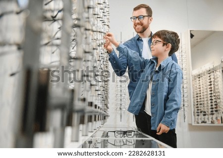 Family buy glasses. Father in a blue shirt. Royalty-Free Stock Photo #2282628131