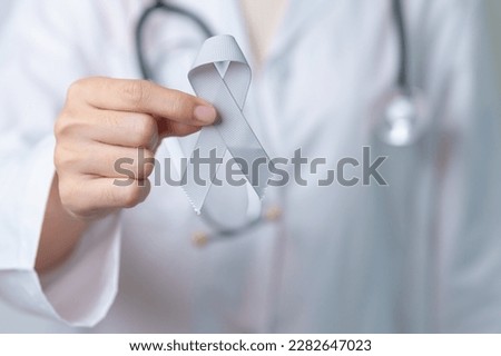 Brain Cancer Awareness May month, Doctor with grey color Ribbon for supporting life people. Healthcare and World cancer day concept Royalty-Free Stock Photo #2282647023