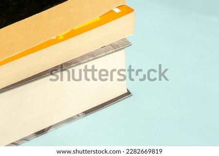 On a blue background lies a stack of books. Beautiful books on a light blue background. Light background for training material.