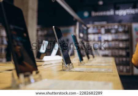 Showcase with smartphones in the modern electronics store. Buy a mobile phone. Many smartphones on the shelf of the technology store Royalty-Free Stock Photo #2282682289