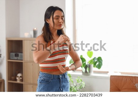 Young woman with pendulum at home Royalty-Free Stock Photo #2282703439
