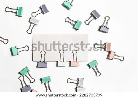 white note hold by metal paper clips isolated over white background, business concept, memory reminder paper, work or educational tools. High quality photo