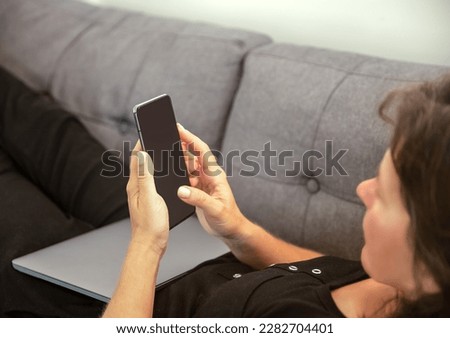 girl holding cell phone in home environment, work from home, relaxed business concept.