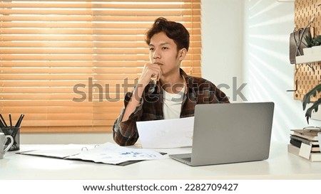 Image of asian male in smart casual wears using laptop at home office. Freelance, distance, education, e-learning concept