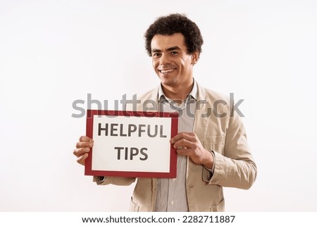 Image of businessman holding paper with text helpful  tips .