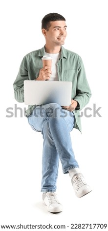 Young guy with cup of coffee and laptop sitting in chair on white background Royalty-Free Stock Photo #2282717709