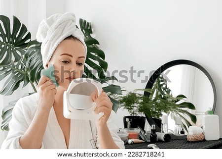 woman does a facial massage with a gouache scraper. Beauty and personal care, skin and face care concept. High quality photo. High quality photo