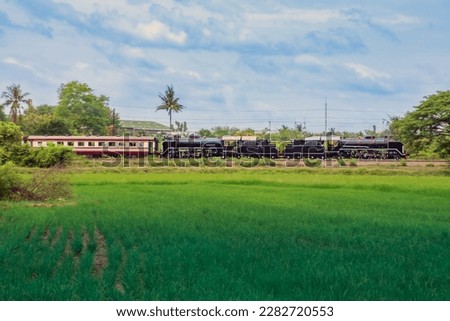 Steam locomotive with passenger train on the railway. Royalty-Free Stock Photo #2282720553