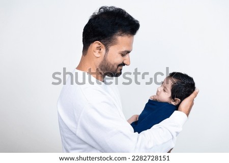 Young indian father holding cute newborn baby in arms. Loving asian dad with  small baby child, Beautiful family, fatherhood. Father's day concept. Royalty-Free Stock Photo #2282728151