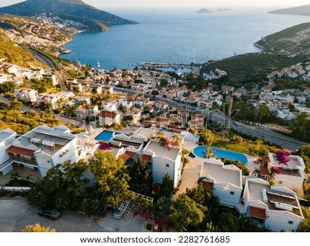 Spectacular aerial drone footage capturing the charming boutique hotels and holiday homes in Kalkan, Kaş, set against the backdrop of the beautiful Mediterranean Sea. Royalty-Free Stock Photo #2282761685