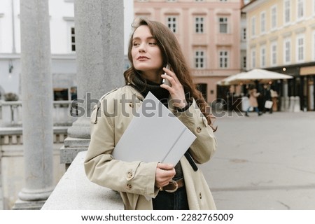 Young successful caucasian woman outside working remotely, having a business call