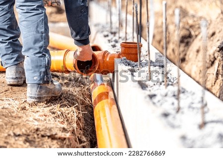 installation of a sewage plastic pipe during the construction of a house Royalty-Free Stock Photo #2282766869