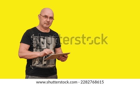 Profile photo of man hold tablet serious look screen typing wear green pullover isolated yellow color background
