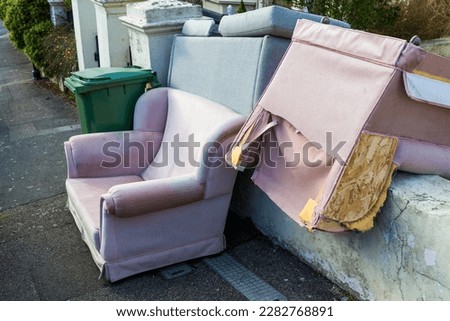 Bulky discarded furniture including armchairs and a settee left outside a house in St Leonards-on-Sea awaiting collection Royalty-Free Stock Photo #2282768891