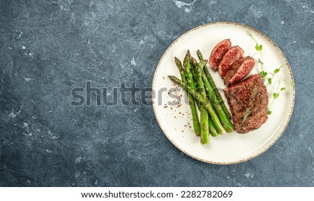 sliced beef grill steak with green asparagus. Healthy dinner or lunch. Long banner format. top view. Royalty-Free Stock Photo #2282782069