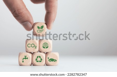 Hands laying wooden blocks, CO2 emission reduction concept in hand for environment. Global warming. Sustainable development. and green business from renewable energy Royalty-Free Stock Photo #2282782347