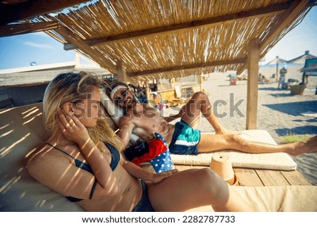 Smiling man and girl sunbathing on a beach and enjoying at summer vacation.