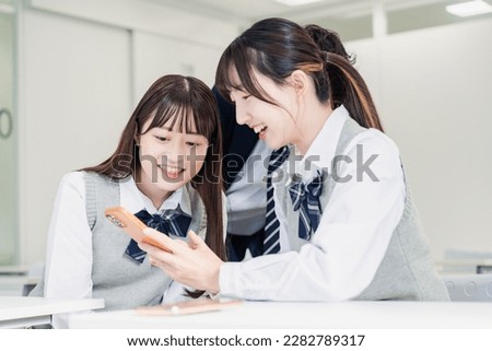 High school students looking at social networking sites together in a classroom Royalty-Free Stock Photo #2282789317