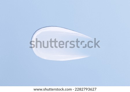 Close-up smear of cream texture on a blue background