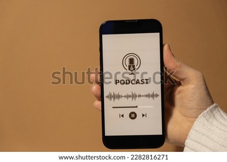 Unrecognizable woman holding mobile phone Podcast listening website page app application with wireless headphones. Audio healing, sound therapy wellness rituals, positive mental health habits