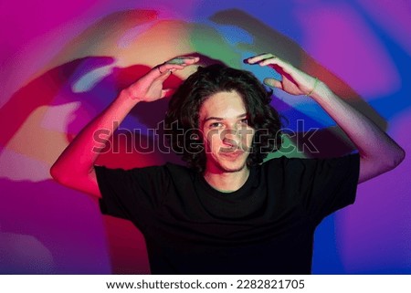 Portrait of young handsome man with colorful shadows on photographic background. rgb colors