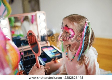 Children face painting. Artist painting little preschooler girl like unicorn on a birthday party. Creative activities for kids Royalty-Free Stock Photo #2282828445