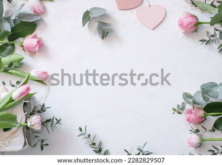 Wedding arrangement of pink spring flowers with heart shape on white background. Top view, flat lay. Flower frame in boho style for a seasonal wedding concept or mother's day greetings with textspace 