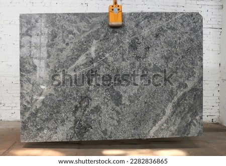 Picture of a marble slab on a hanger, shot in natural light, a cut of decorative marble in a warehouse, a large piece of marble