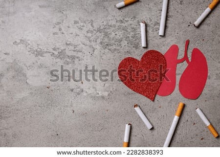 Quit smoking for better health concept. Cigarettes with red heart and lungs paper shape on gray background. Copy Space.