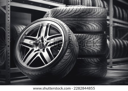 A set of summer wheels in a tire warehouse, against the background of tire racks. Beautiful cool alloy wheels on a black background, seasonal tire fitting and overshooting, wheel storage Royalty-Free Stock Photo #2282844855