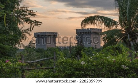Good morning concept. Nature landscape background. Towers castle green palms fairytale mood. Sunrise sky orange clouds 