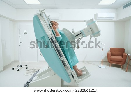 Adult man taking radiograph an X-Ray machine to scan for injury Royalty-Free Stock Photo #2282861217