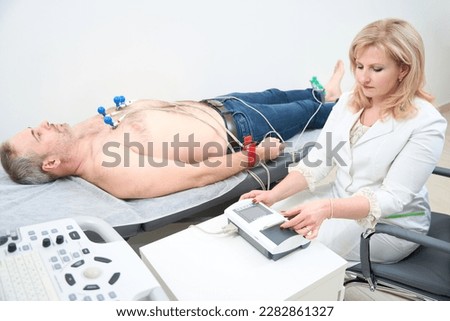 Heart ultrasound exam for adult man with ultrasound specialist while medical exam