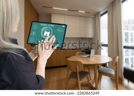 Side view pleasant young woman using smart home system or activating modern alarm system before leaving apartment. Happy lady turning off easy security technology, when returning house or flat Royalty-Free Stock Photo #2282865249