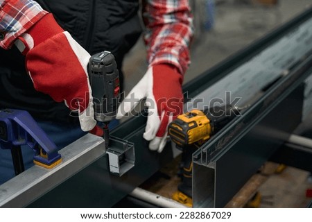 Close up photo of male assembling metal structure