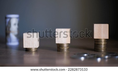 Blank wooden cubes with banknotes and coins financial concept