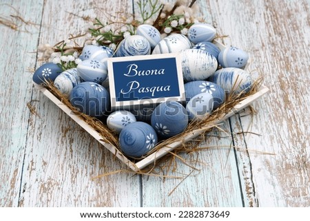 Nest with blue Easter eggs with Easter greetings in Italian. Italian inscription means Happy Easter. Royalty-Free Stock Photo #2282873649