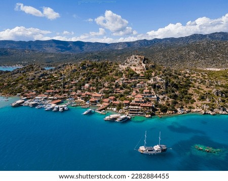Aerial drone shot of Simena Castle (Kaleköy), beach, and yachts, displaying the historic site and enchanting Mediterranean landscape in Antalya, Turkey. Royalty-Free Stock Photo #2282884455