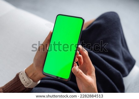 Woman hold with cellphone with green screen