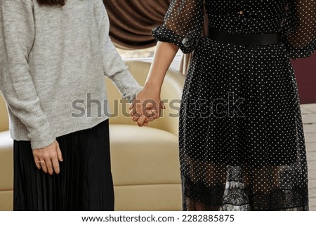 A woman puts her arm around another woman