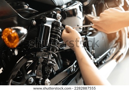 Mechanic using Tools set up suspension sag Compression and Rebound on a motorcycle in garage,maintenance motorcycle concept .selective focus Royalty-Free Stock Photo #2282887555