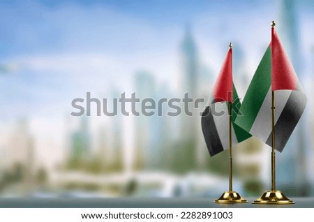 Small flags of the Arab Emirates on an abstract blurry background.