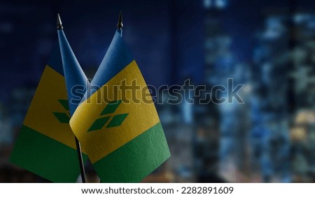 Small flags of the Saint Vincent on an abstract blurry background.