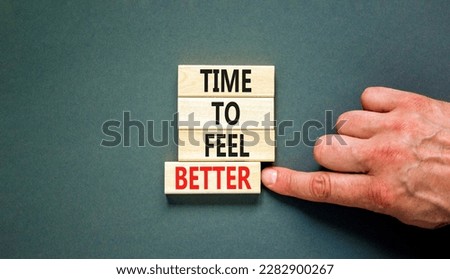 Time to feel better symbol. Concept words Time to feel better on wooden block. Beautiful grey table grey background. Businessman hand. Motivational business time to feel better concept. Copy space