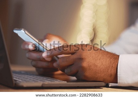 Business man, hands and phone by a laptop typing a message for work networking. Hand closeup, bokeh and online management of a employee working and planning a job schedule with technology and email