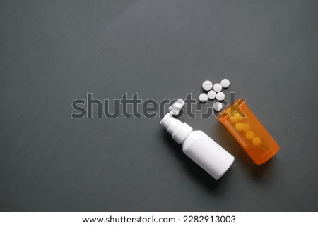 ear spray and medical pill on table 